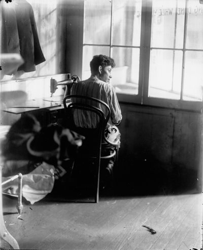 Tailor Seated at Sewing Machine Beside a Window by Louis Block